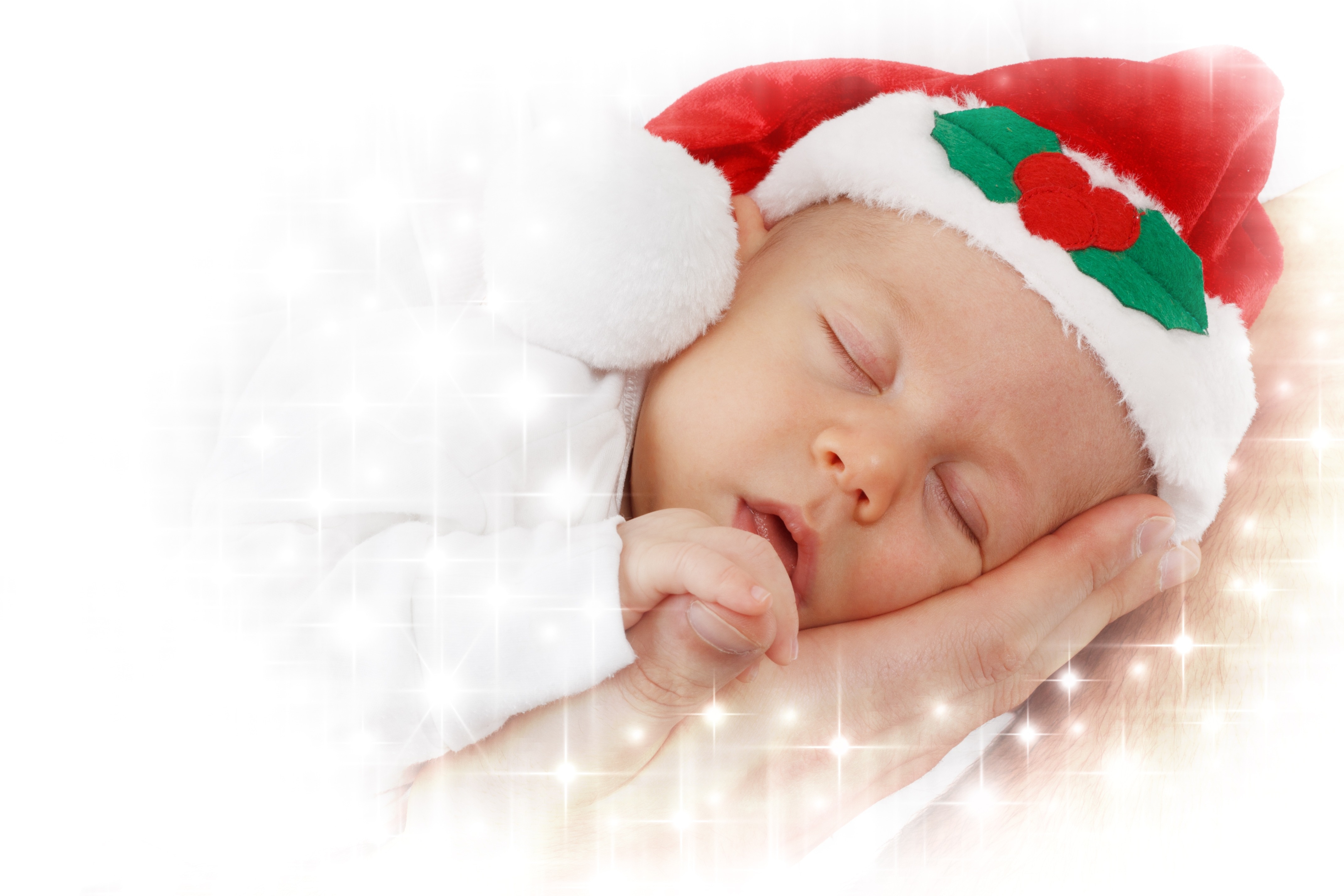 sleeping baby wearing red and white santa hat
