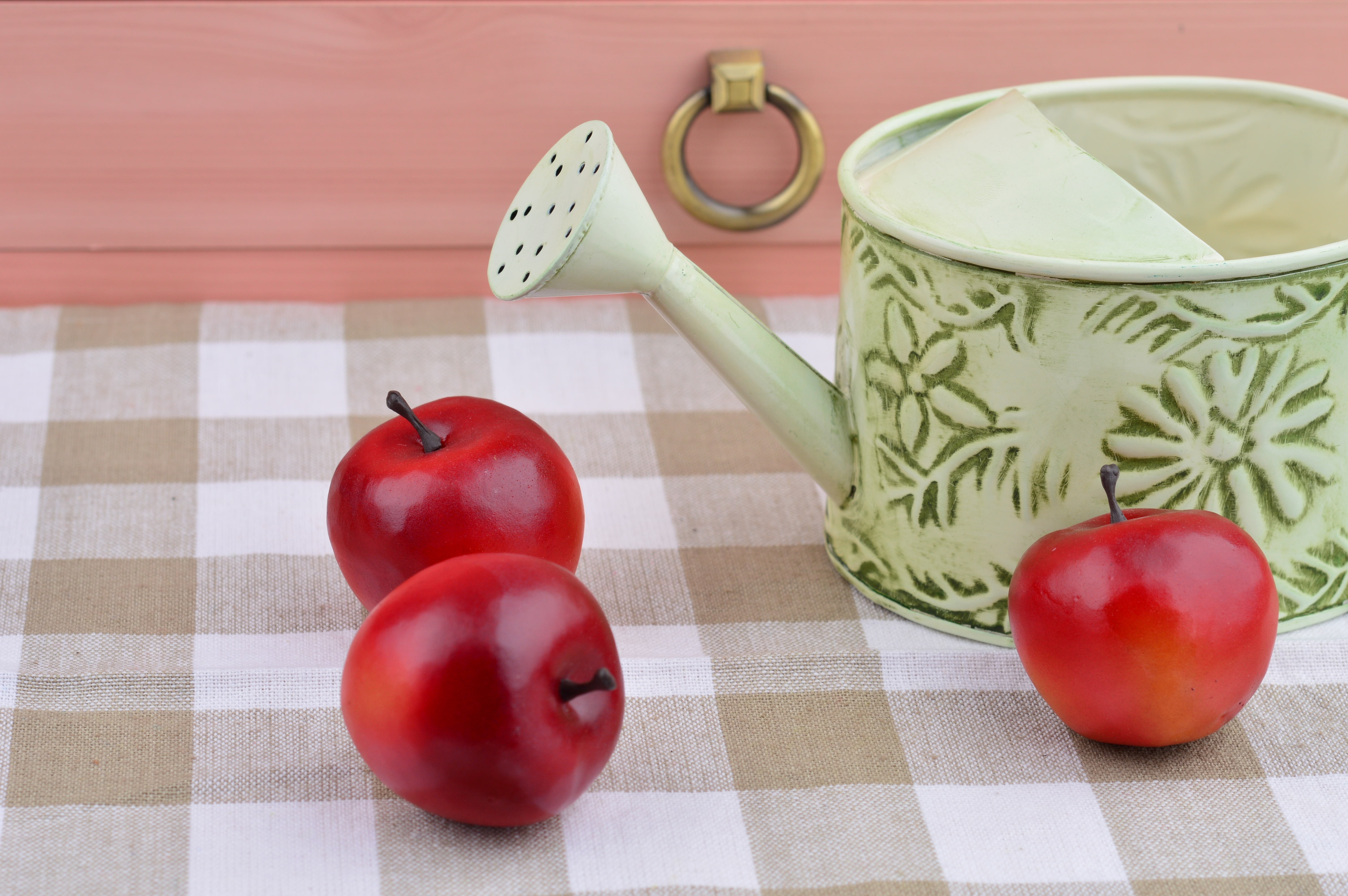 3 red apple fruits and watering can