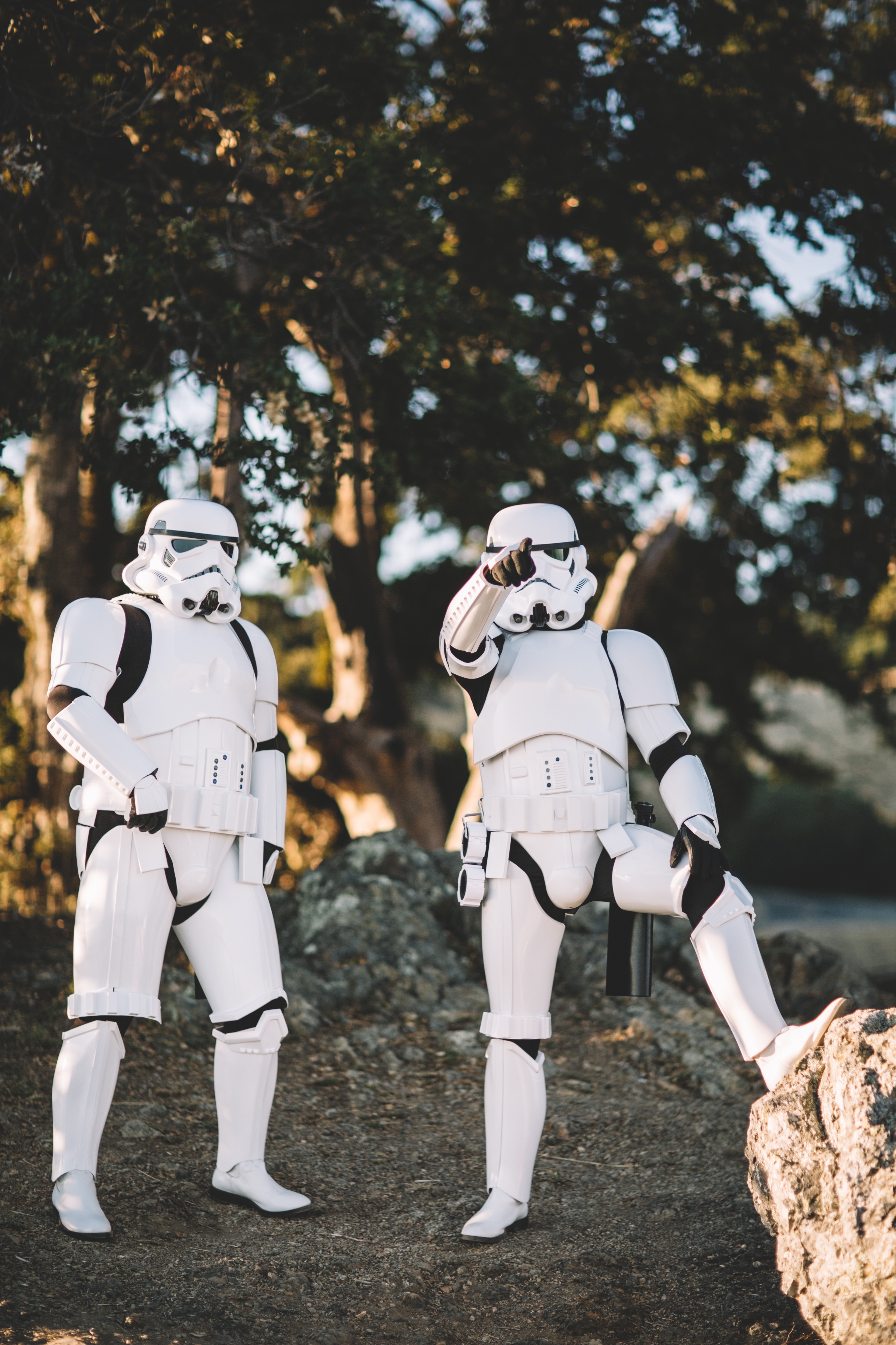two storm troopers standing in front of trees