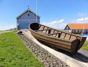 brown wooden boat on concrete road during day time thumbnail