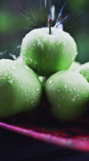 wet green apples on pink tray thumbnail