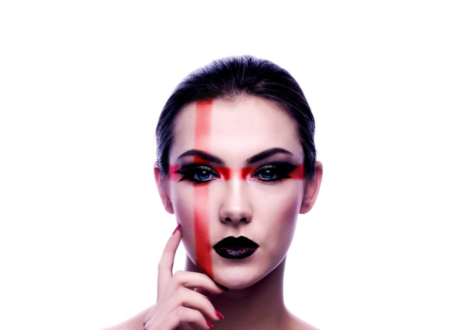 woman with black lisptick and eyeshadow with red cross print on face preview
