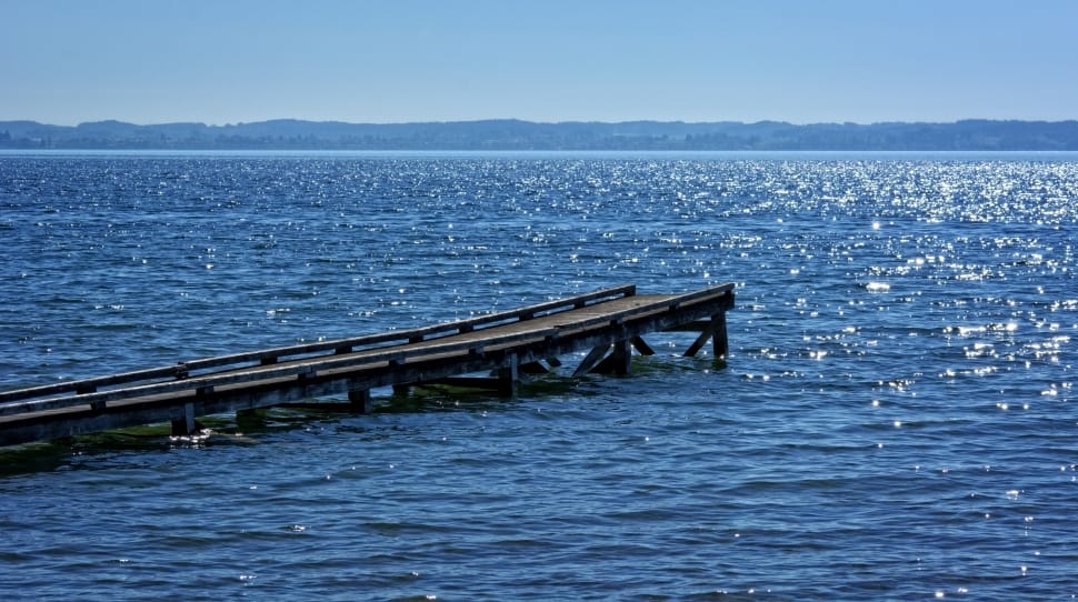 brown wooden dock surrounded by body of water during daytime preview