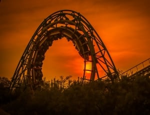 roller coaster on top with people riding during gold hour thumbnail